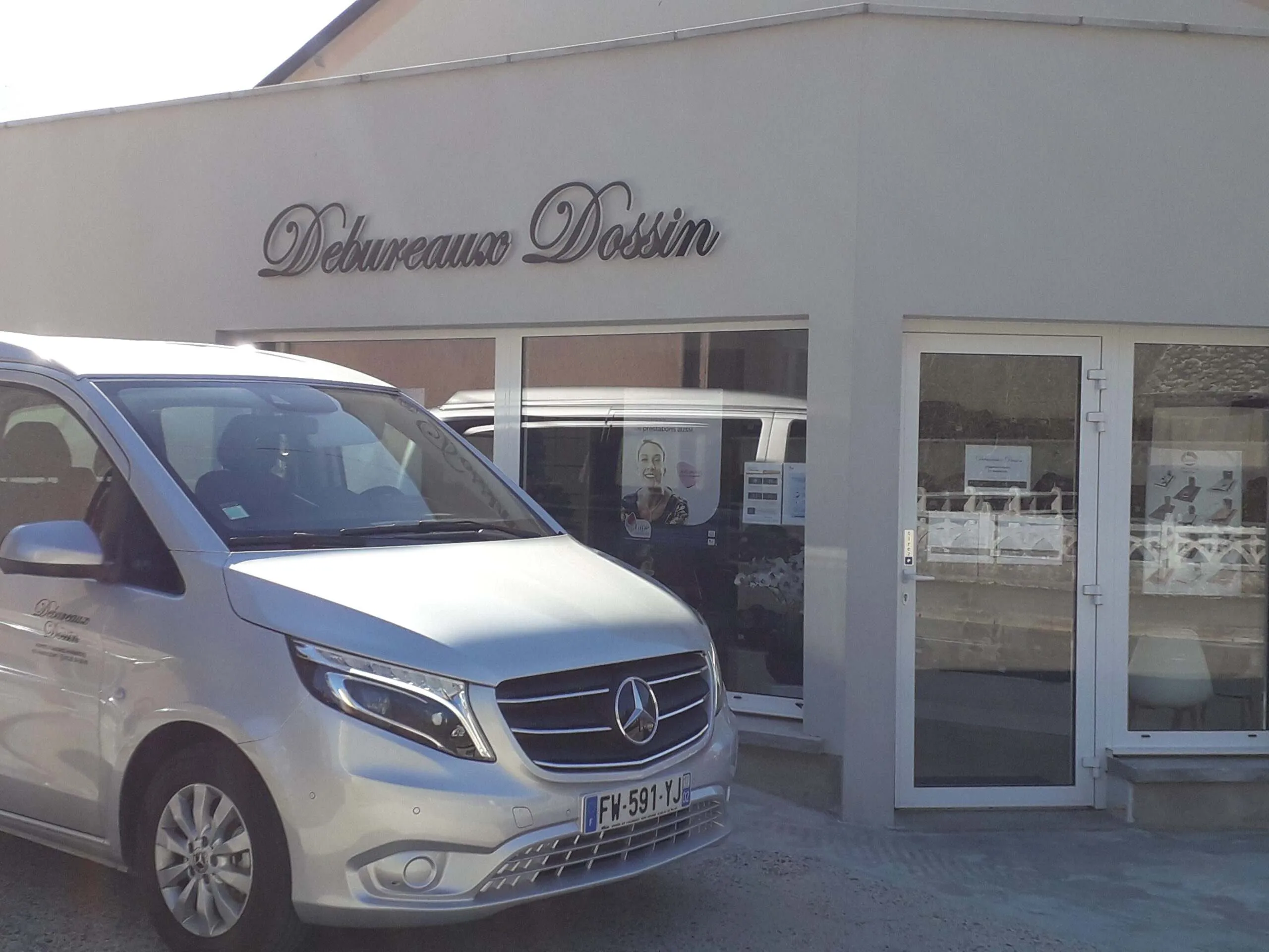 Véhicule corbillard Mercedes argenté garé devant l'agence Debureaux Dossin