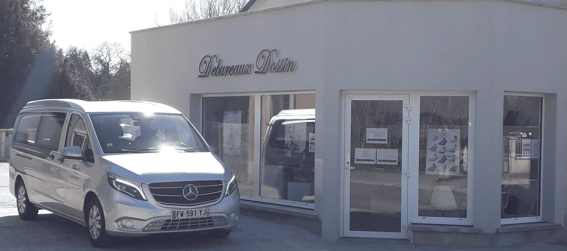 Vue rapprochée de la devanture de l'agence Debureaux Dossin avec son véhicule de transport