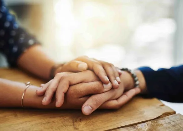 Mains jointes pour exprimer le soutien et la condoléance pendant le deuil