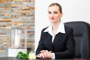 Conseillère funéraire souriante assise à son bureau pour un contrat de prévoyance